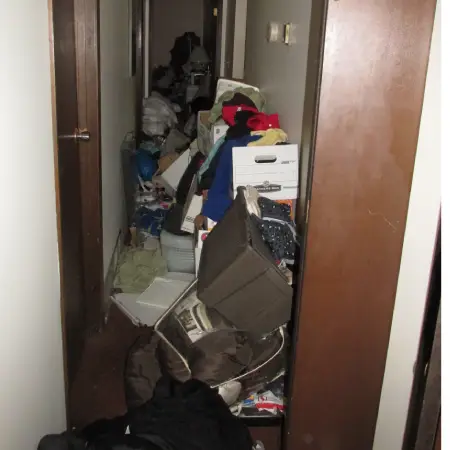 Logement en état de syndrome de Diogène avant intervention — pièce encombrée